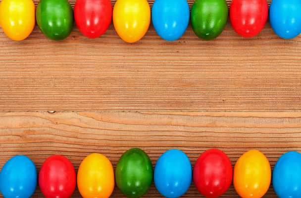 Ovos de Páscoa enquadrando uma velha superfície de mesa de madeira
 - Foto, Imagem