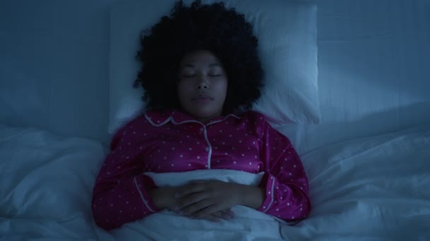 Top view of African American woman seeing nightmare in scary dream. Young woman yelling loud in fear and panic. Disturbed frightened shocked girl suddenly woken up in bed fell asleep late, home night - Séquence, vidéo