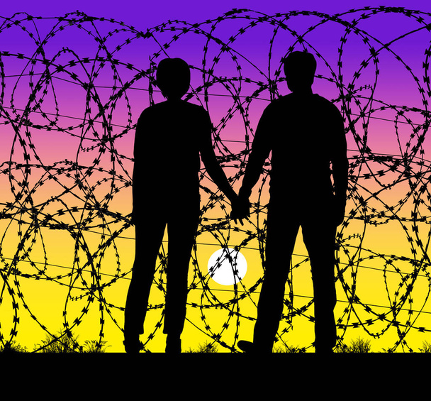 夫婦は手を取り合い、米国とメキシコの国境でかみそりのワイヤーフェンスを通して夕日を見ます。彼らはアメリカを見るためにかみそりのワイヤーを通してだけ見ることができない. - 写真・画像