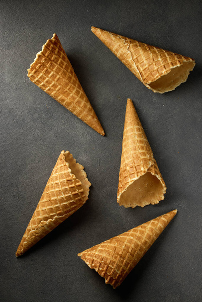 waffle ice cream cones on dark grey background, top view - Foto, imagen