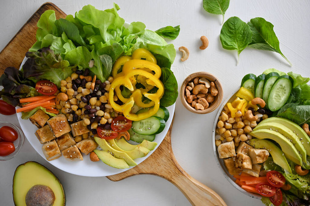Top view of a healthy green fresh salad with grilled tofu. sweet peppers, chickpeas, avocado, beans, green salad and tomatoes. Diet and vegan food concept - Foto, Bild