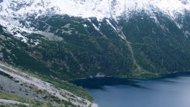 Top view on Tatra National Park, Poland. Aerial view Famous Mountains Lake Morskie Oko Or Sea Eye Lake In autumn. Snow covered mountain peaks on background. Blue water nature landscape 4k - Materiał filmowy, wideo