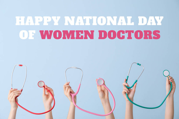 Greeting card for National Day of Women Doctors with many hands holding stethoscopes on light blue background - Photo, Image