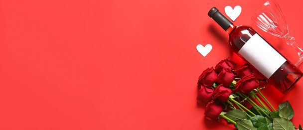 Μπουκάλι κρασί, τριαντάφυλλα, ποτήρι και καρδιές σε κόκκινο φόντο με χώρο για κείμενο. Γιορτή του Αγίου Βαλεντίνου - Φωτογραφία, εικόνα
