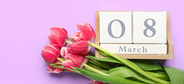 Ημερολόγιο με ημερομηνία της Παγκόσμιας Ημέρας της Γυναίκας και λουλούδια τουλίπας σε λιλά φόντο - Φωτογραφία, εικόνα