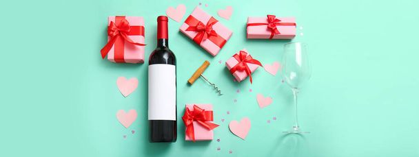Композиція з пляшкою вина, скла, подарунків і декору на бірюзовому тлі. День святого Валентина. - Фото, зображення