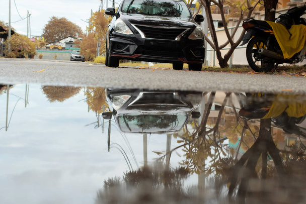 Застоявшийся бассейн водной сцены после дождя на асфальтовой улице в пригороде  - Фото, изображение