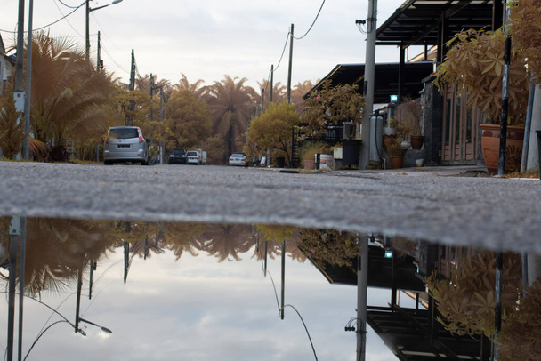 Застоявшийся бассейн водной сцены после дождя на асфальтовой улице в пригороде  - Фото, изображение
