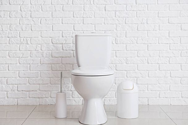 Modern toilet bowl near white brick wall - Foto, Bild