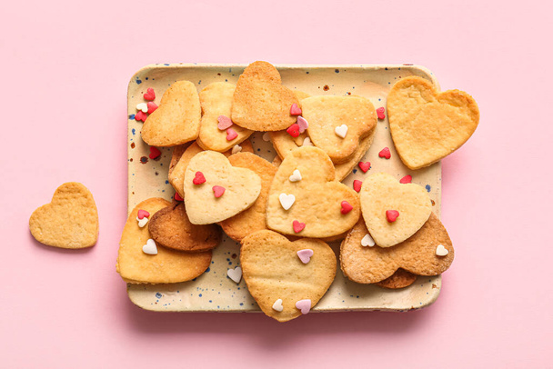 Plate with sweet heart shaped cookies and sprinkles on pink background. Valentines Day celebration - Photo, image