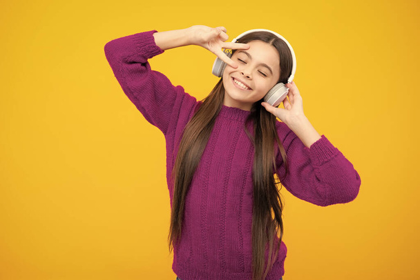 Стильна дівчина-підліток слухає музику з навушниками. Концепція дитячого способу життя. Бездротові навушники
 - Фото, зображення
