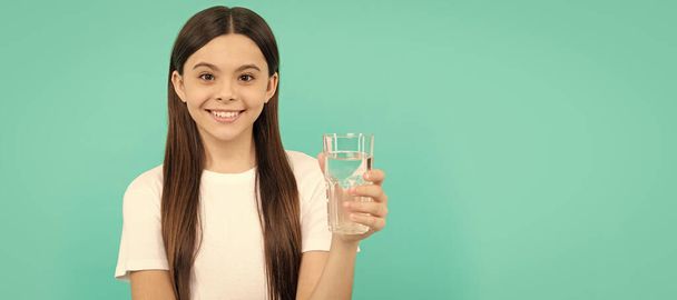 dospívající dívka bude pít minerální nápoj. zdravý životní styl v dětství. vodní bilance. Banner dětské dívky se sklenicí vody, studiový portrét s kopírovacím prostorem - Fotografie, Obrázek