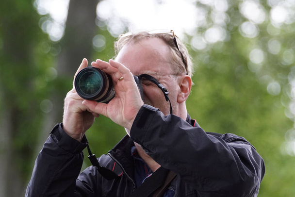 One man photographing through a camera outdoors  - Fotó, kép