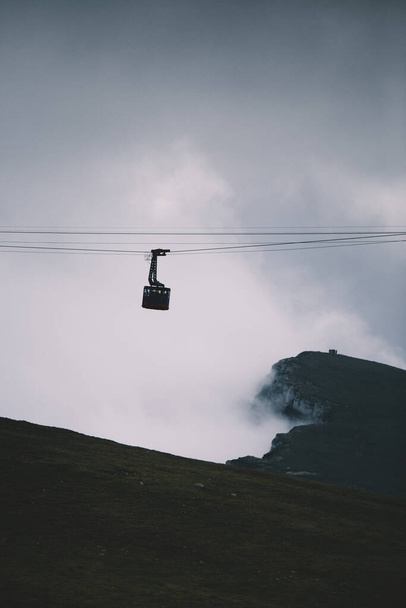 Cableway over the foggy valley in the mountains - Foto, Bild