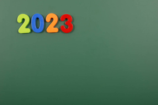 2023 año escrito en letras magnéticas de plástico brillante pegado en una placa magnética - Foto, imagen
