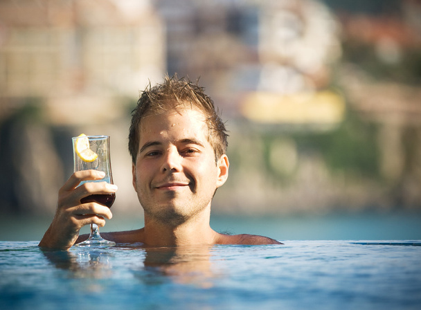 Man with glass at pool - Foto, Imagen