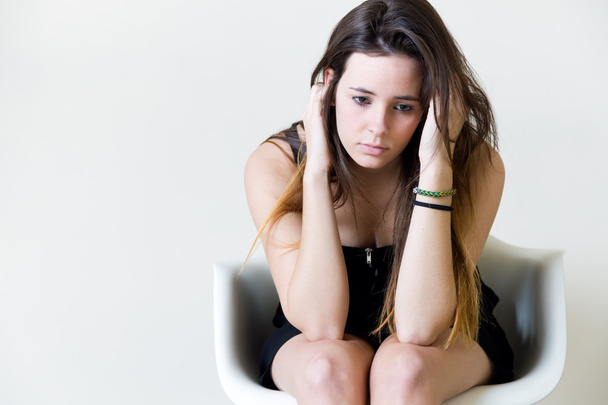 Deprimida jovem mulher sentada em casa
. - Foto, Imagem