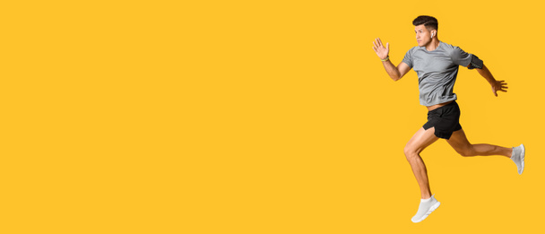 Sporty running man on yellow background with space for text - Fotografie, Obrázek