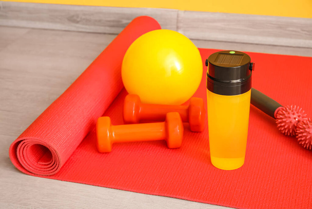 Sports water bottle with equipment on mat, closeup - Foto, immagini