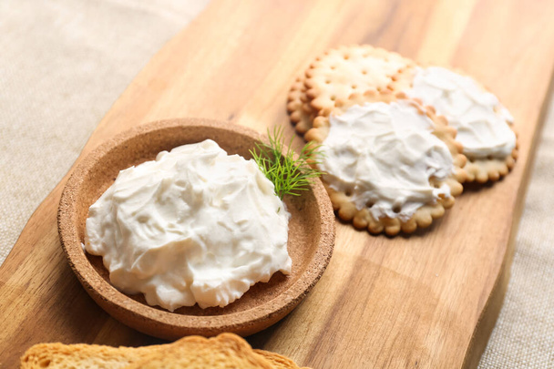 Bowl of tasty cream cheese and crackers on table, closeup - Foto, afbeelding