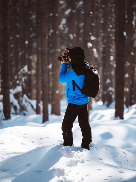 Nature photographer taking photos from the frozen trees during winter in the forest - Photo, Image