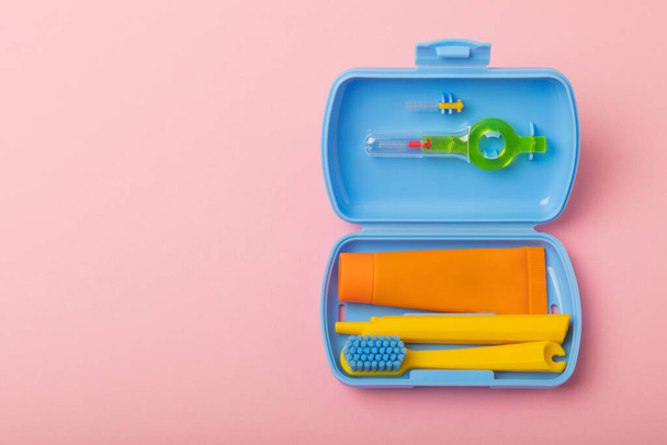 Oral care. Travel cosmetic bag with a toothbrush and toothpaste in a case. Composition on a bright pink background. Dentist concept. Flat lay. copy space.Place for text.Fletley. - Foto, Imagen