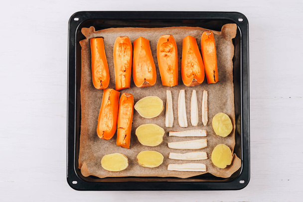 Roasted vegetables on oven tray. Pumpkin, potato and parsnip root. Vegetarian, healthy food. Top view, flat lay. - Foto, immagini