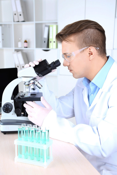 Mężczyzna naukowiec stosujący mikroskop w laboratorium - Zdjęcie, obraz