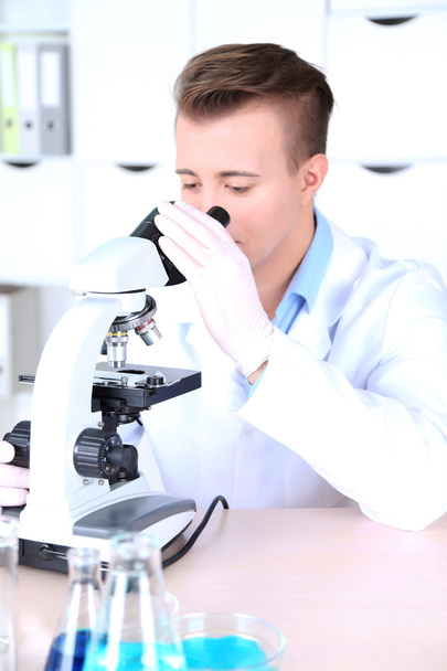 Científico masculino usando microscopio en laboratorio
 - Foto, Imagen