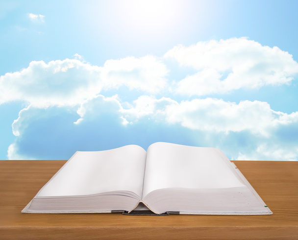Livro aberto sobre prancha de madeira fundo céu brilhante
 - Foto, Imagem
