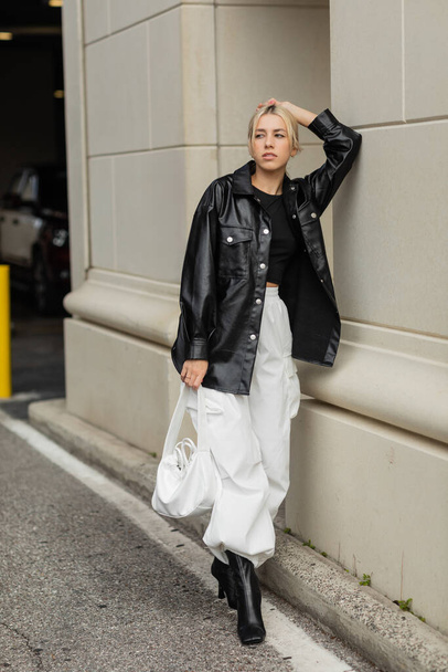 pełna długość blondynka kobieta w stylowy strój i buty pozowanie z torebki na ulicy w Miami  - Zdjęcie, obraz