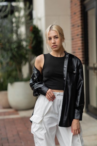 young blonde woman in leather shirt jacket posing with handbag in Miami  - Valokuva, kuva