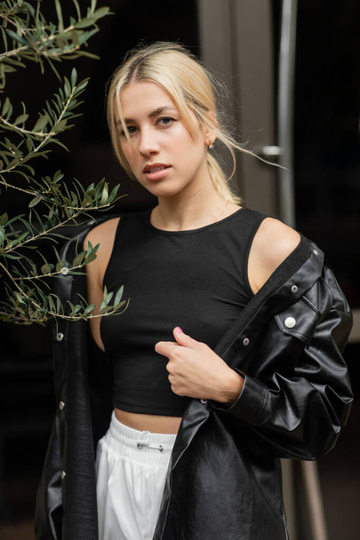 blonde woman in leather shirt jacket and tank top standing on street in Miami  - Fotó, kép
