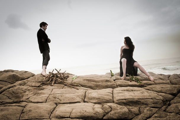 美しいカップルがいちゃつくとビーチの岩の上で一緒に楽しんで - 写真・画像