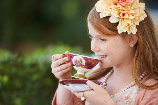 This tea party is really fun. A cute little girl having a tea party outside - Fotoğraf, Görsel