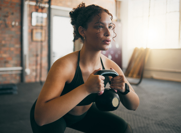 Exercise, kettlebell and a woman at gym breathing during workout, exercise and weight training for body wellness. Strong sports female or athlete with weights for power, muscle and healthy lifestyle. - Photo, Image