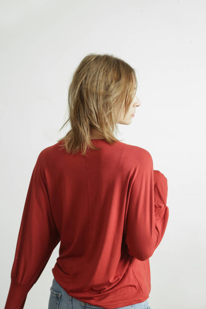 Studio photo of young female model wearing orange shirt made from organic cotton. Comfortable sustainable fashion. - Foto, Bild