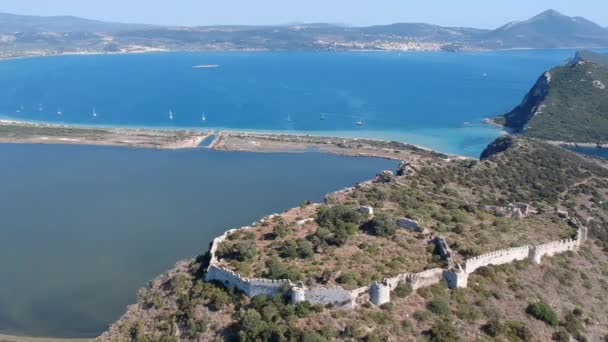 Aerial panorama view over the famous castle of Navarino located on the top of semicircular sandy beach and lagoon, Voidokilia in Messenia, Greece - Filmagem, Vídeo