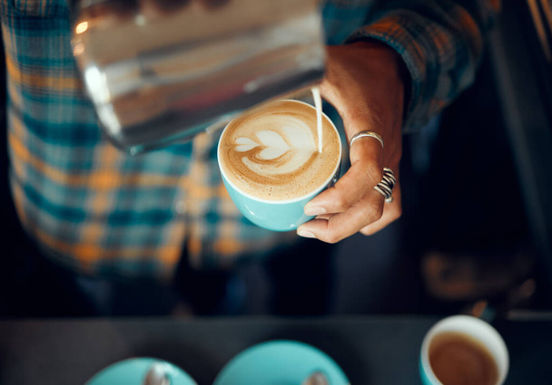 Coffee, milk and hands of man in cafe for cappuccino, breakfast and caffeine beverage. Relax, espresso and dairy with barista in coffee shop with latte art for retail, mocha and drink preparation. - Fotó, kép