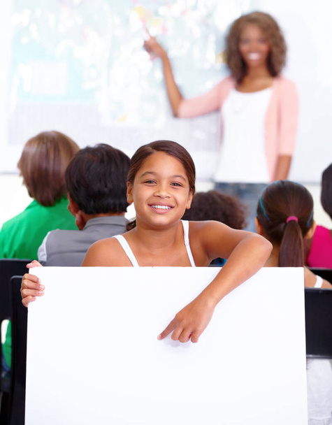 Наш урок на сегодня. Портрет молодой школьницы, удерживающей ваше копирайт-пространство в классе - Фото, изображение