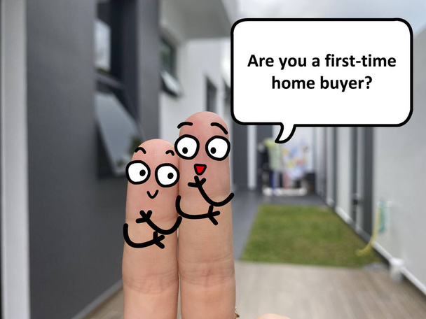 Two fingers are decorated as two person standing outside a new house. One of them is asking another if he is a first time home buyer. - Valokuva, kuva