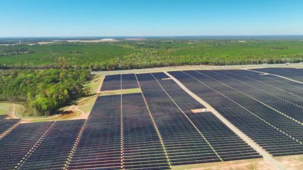 Luchtfoto van een grote duurzame elektriciteitscentrale met vele rijen fotovoltaïsche zonnepanelen voor de productie van schone elektrische energie. Hernieuwbare elektriciteit zonder uitstoot. - Video