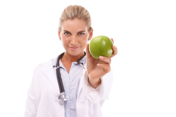 Doctor, studio portrait and woman with apple for nutrition, wellness and health by white background. Happy isolated nutritionist, fruit and advice for healthcare, natural diet and healthy food. - Foto, immagini