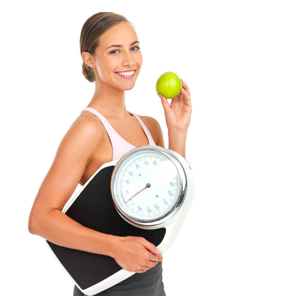 Υγεία, φυσική κατάσταση και γυναίκα με κλίμακα και μήλο για τη διατροφή, την απώλεια βάρους και το σώμα φροντίδα πορτρέτο απομονώνονται σε λευκό φόντο. Τρόφιμα, άσκηση και ευεξία, βάρος και φρούτα, κίνητρα υγιεινής διατροφής. - Φωτογραφία, εικόνα