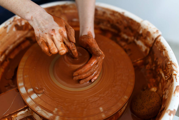 Cropped Image of Unrecognizable Female Ceramics Maker working with Pottery Wheel in Cozy Workshop Makes a Future Vase or Mug,Creative People Handcraft Pottery Class - Foto, Imagen