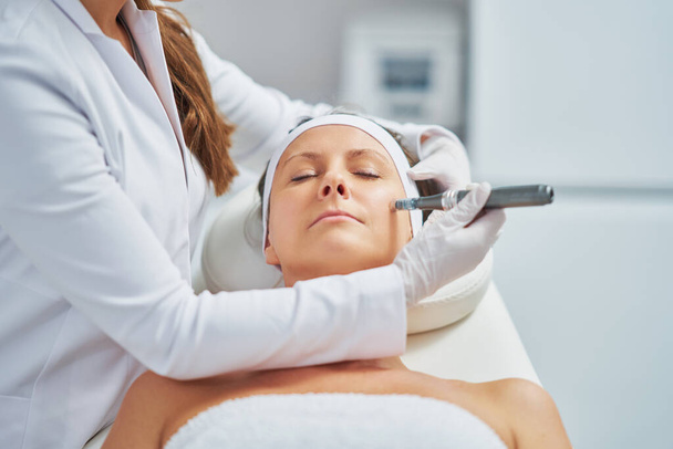 Woman in a beauty salon having needle mesotherapy treatment. High quality photo - Fotó, kép