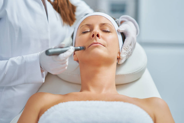 Woman in a beauty salon having needle mesotherapy treatment. High quality photo - Fotografie, Obrázek