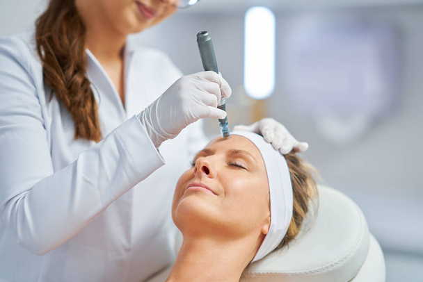 Woman in a beauty salon having needle mesotherapy treatment. High quality photo - Foto, Imagem