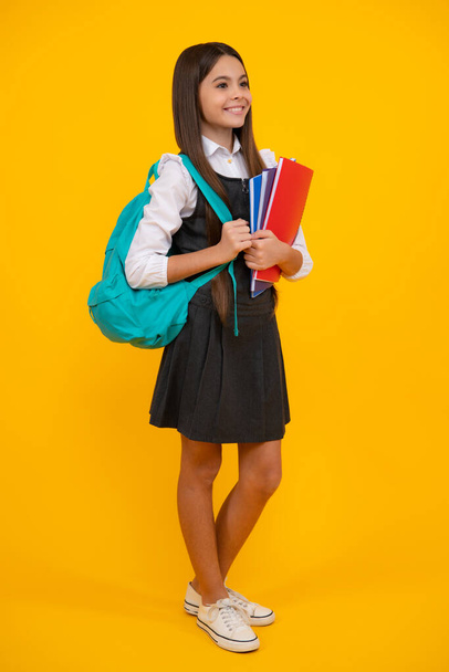 School teenager child girl with school backpack hold book and copybook. Teenager student, isolated background. Learning and knowledge. Go study - Photo, image
