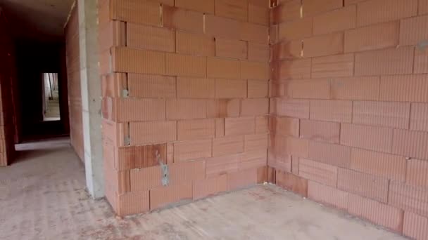 工事中の建物の未完成の部屋のインテリア。赤レンガの壁。新しい家 - 映像、動画